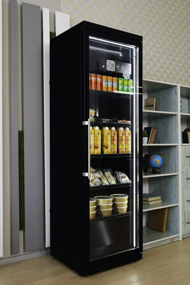 Black cabinet with a glass door next to bookshelves, juice and packaged food on its shelves