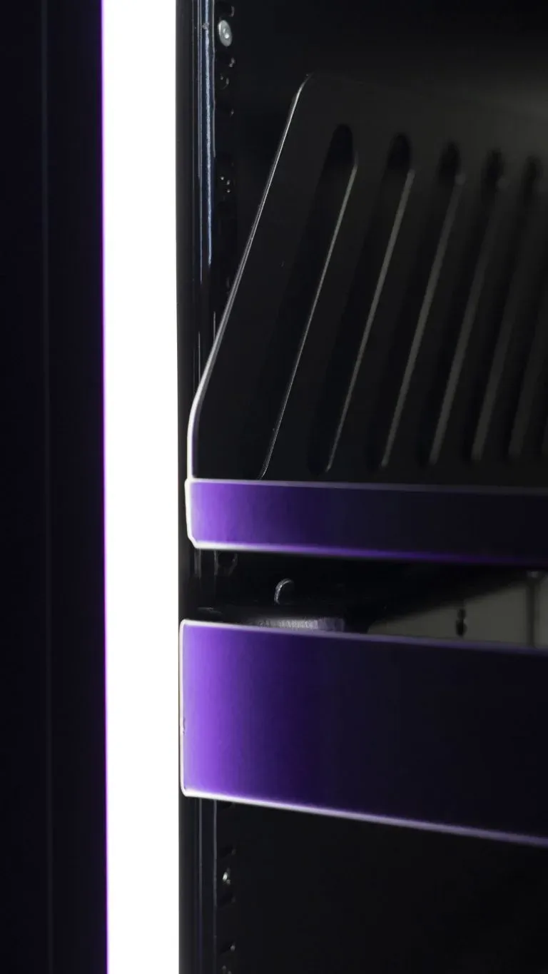 Front edges of two shelves inside a cabinet under dim lighting