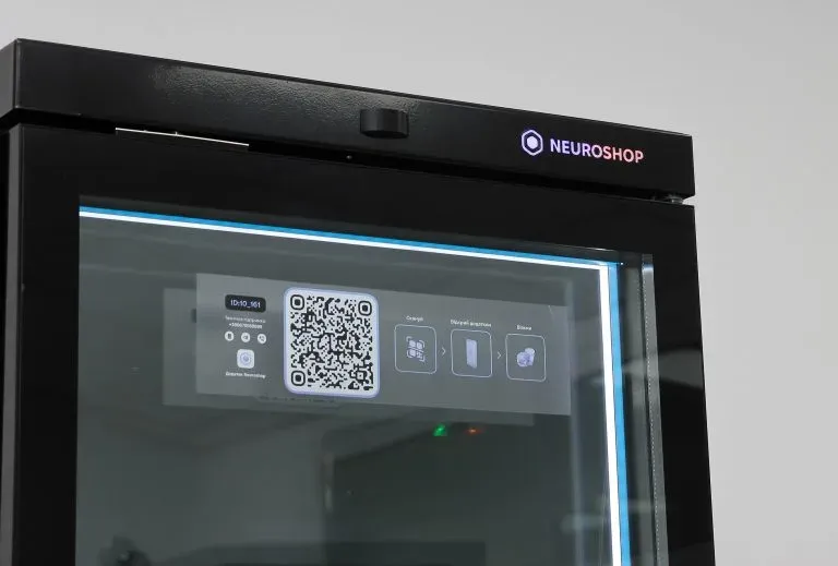 Top of a cabinet with the Neuroshop logo, a sticker on the glass with a QR code and pictograms of the purchase steps