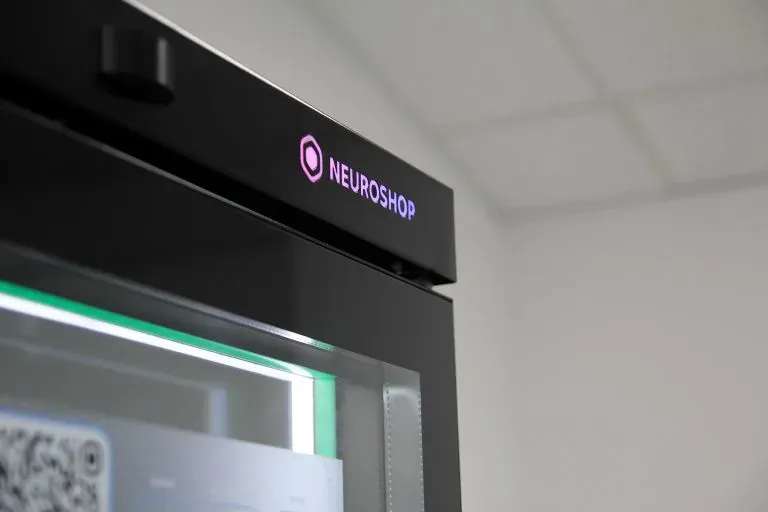 Top corner of a cabinet with a lit Neuroshop logo and green light along the edge of the glass door