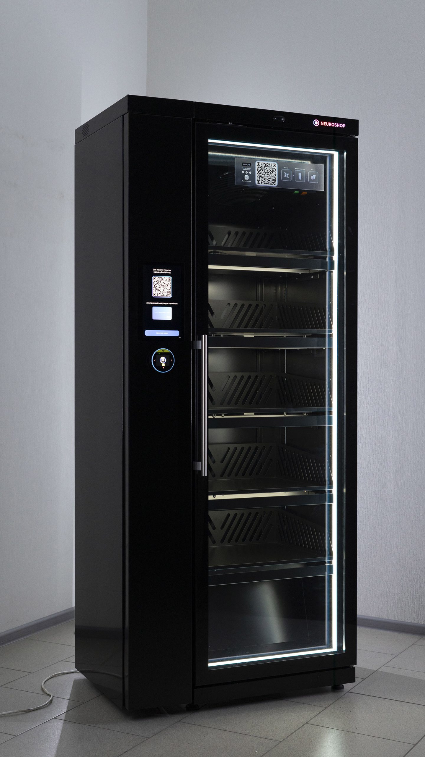 Black cabinet with a glass door, empty lit shelves inside, a screen with a QR code on the front panel