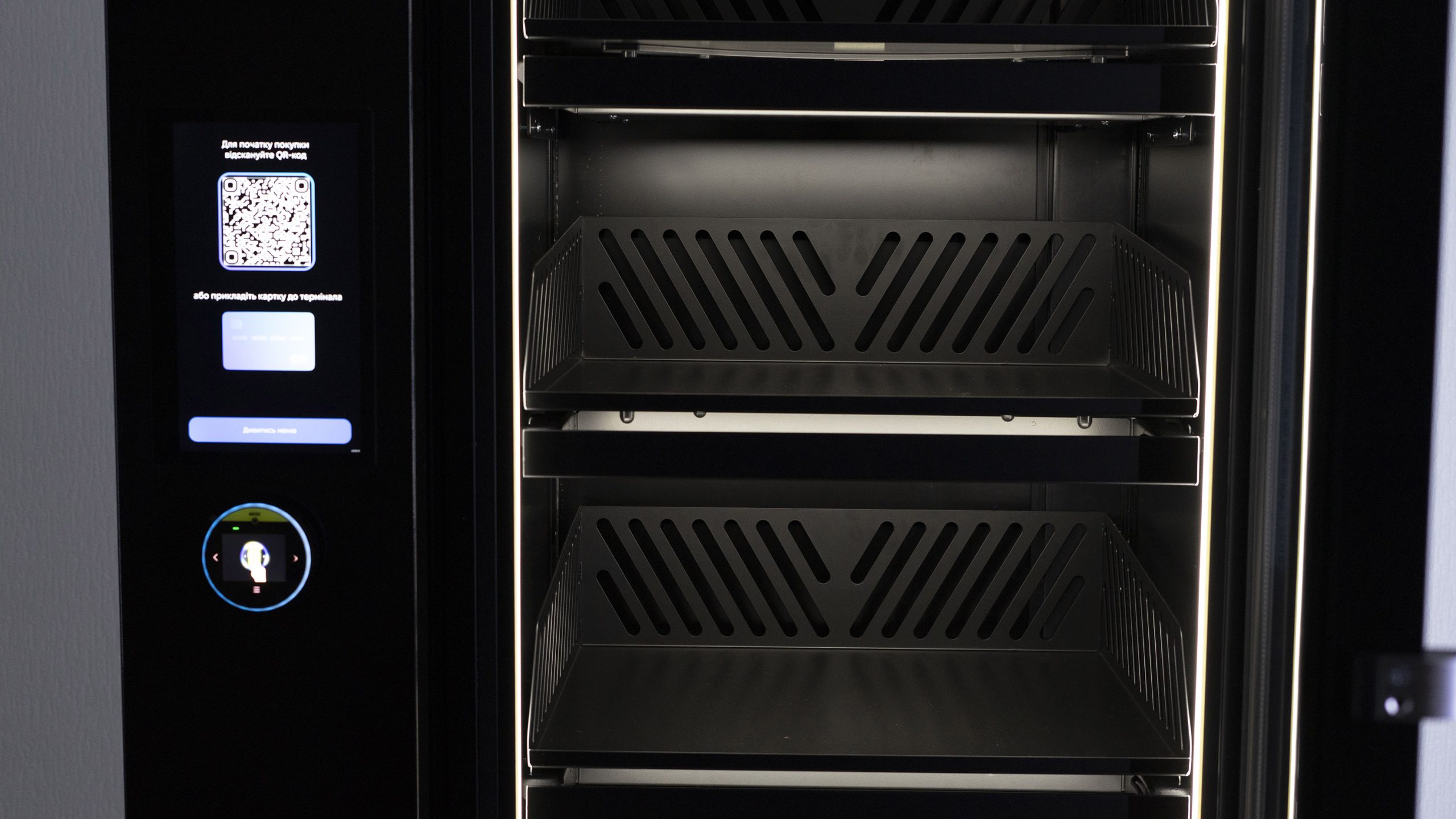 Front panel to the left of the cabinet door with a screen, a QR code and a card reader, empty basket shelves alongside